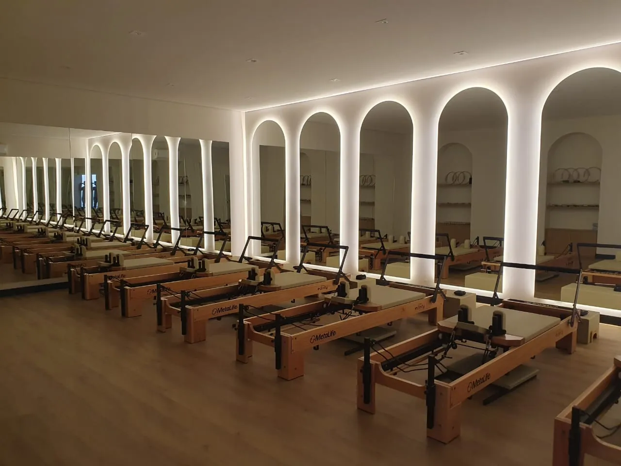 Estúdio do Bloom Wellness Club com arcos iluminados, obra entregue